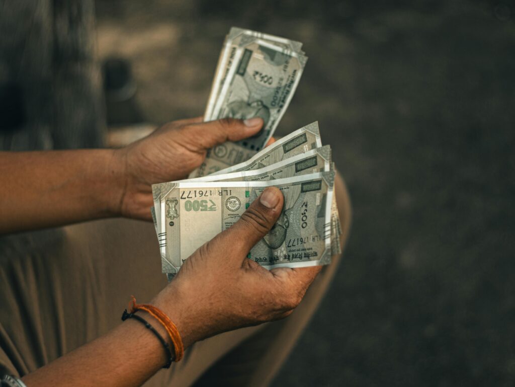 Close-up of hands holding multiple 500 Indian Rupee notes, representing wealth and financial transactions.